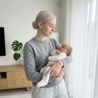 Thumbnail for A woman holding a baby, showcasing the Photo Projection Bracelet by Brother & Sisters.