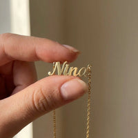 Thumbnail for Minimalist Name Necklace pendant held between two fingertips showing its true size, the name Nina | SKU: minimalistnn-gold