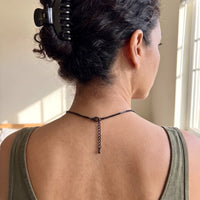 Thumbnail for Back of the neck of a woman with a hair clip showing the clasp and extension chain of the black clover photo necklace | SKU: TPH-CLVN-BLACK